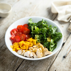 Homemade chicken bowl with mango and kale