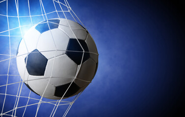 Soccer ball in goal on blue