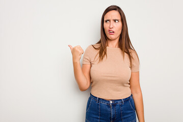 Young caucasian cute woman isolated on white background shocked pointing with index fingers to a copy space.