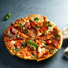 Homemade pizza with sausage and pesto sauce