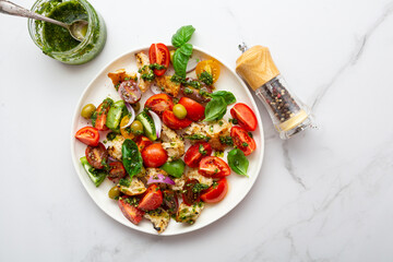 Top view of fresh tomato crouton salad with pesto