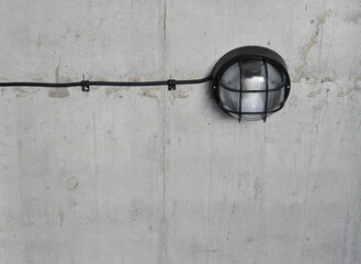Close up concrete wall, industrial loft  metal old black lamp , black cable on the wall, industrial interior design, copy space, black and cable on top