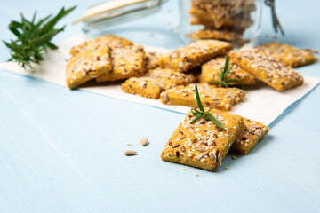 Gluten free Homemade Crackers and Rosemary for Appetizer on Blue Wooden Background.