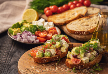 Tasty and healthy avocado, cherry tomatoes and feta cheese sandwiches. Toasts  with avocado, tomatoes and feta cheese.