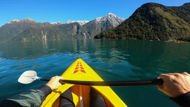 A Person Kayaking In Milford Sound With Mitre Peak In South Island, New Zealand. POV
