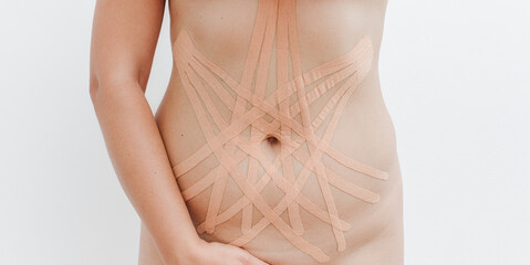 Women's body with kinesio tape on the abdomen. Kinesiology taping concept. - obrazy, fototapety, plakaty