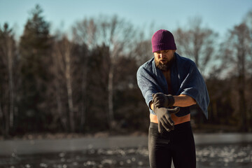 Caucasian adult man go out of frozen lake in the winter