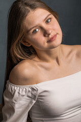 Fototapeta na wymiar young teenage girl on dark studio wall background