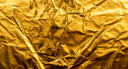 Bright yellow texture of crumpled and creased gold foil or leaf for background.