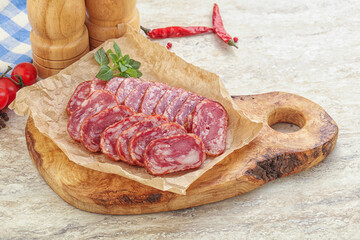 Sliced salami sausages over board