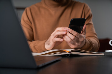 Businessman wearing casual wear sitting typing on smartphone at office