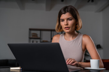 Fototapeta premium Thoughtful businesswoman in casual wear typing on laptop at office