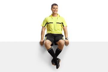 Full length portrait of a football referee sitting on a blank panel