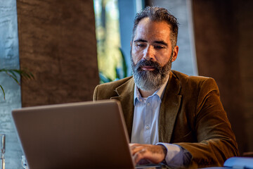 Businessman working in cafe using laptop.