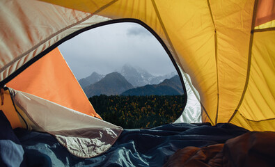 View from the yellow tent to snowy mountains in the morning. Travel in the wild or camping. Active...