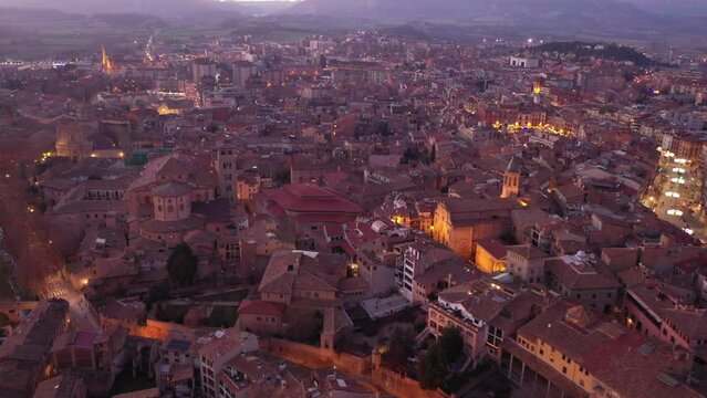 Scenic view from drone winter Vic townscape overlooking central streets decorated with Christmas lighting on eve of holidays, Catalonia, Spain. High quality 4k footage