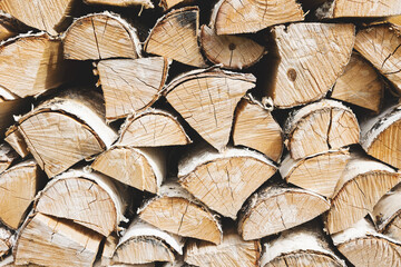 Firewood background. Dry chopped wooden logs. Natural texture.