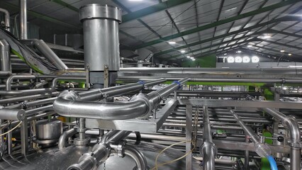 Stainless steel pipes in production room of factory to flow water and milk