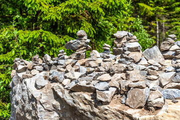 Pyramids of stones in Karelia. Pyramids of stones on background of green forest. Natural stones on top of each other. Balancing stones in the forest.