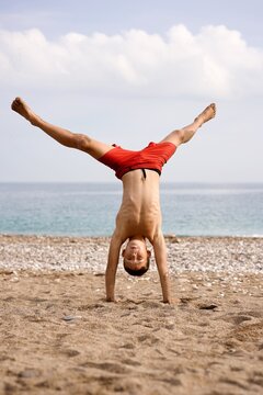 kid does acrobatics on the beach. High quality photo