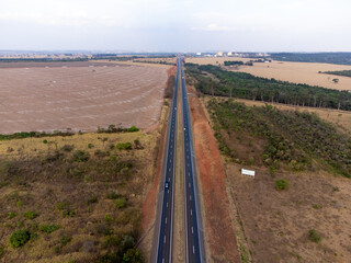 Fototapeta na wymiar large highway in dry grass scenery amidst the farms