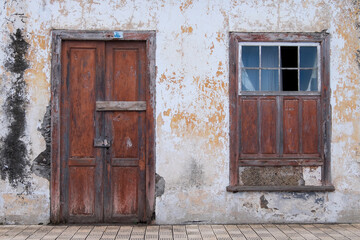 Fachada con puerta y ventana de madera en una casa abandonada de Canarias