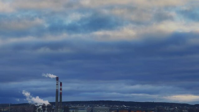 View of the tall chimneys of an industrial enterprise with a chimney polluting the atmosphere. The plant for the production of strategic intercontinental missiles "Topol-M". Russia, Votkinsk 2022