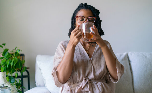 Young woman enjoying warm cup of tea