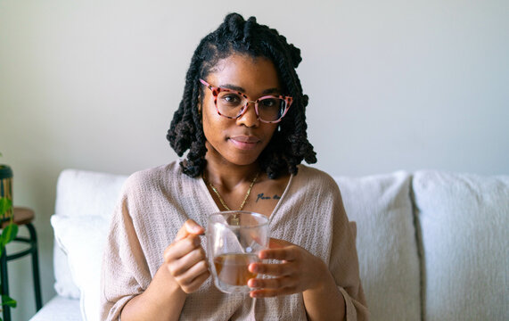 Young woman enjoying warm cup of tea