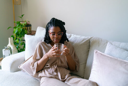 Young woman enjoying warm cup of tea