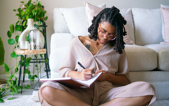 Young woman journaling in her home