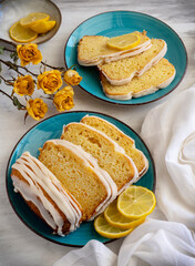 Lemon cake on blue plates with lemons. Delicious fresh homemade dessert.