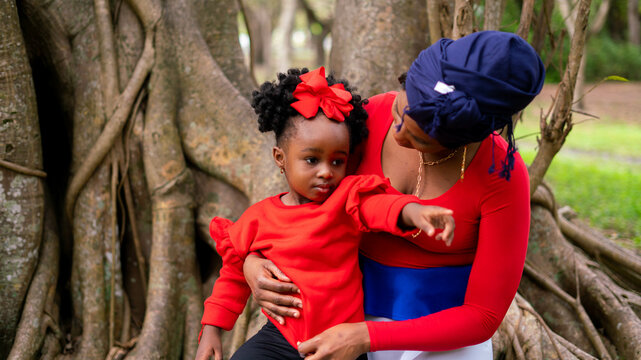 Woman and her daughter sitting together in a tree