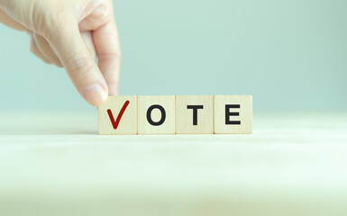 Election vote concept. Vote word with checkmark symbol on wooden cube blocks. Political election campaign logo. Applicable as part of badge design. Voting symbols design. Elections and poll icons.