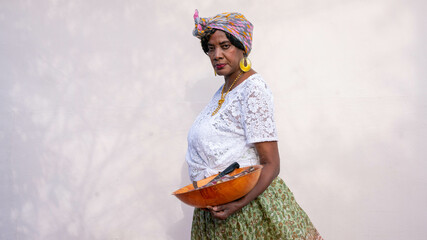 Woman in headwrap holding bowl of sugarcane