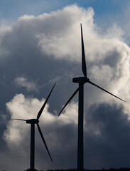 Wind turbine silhouettes, stormy sky background.