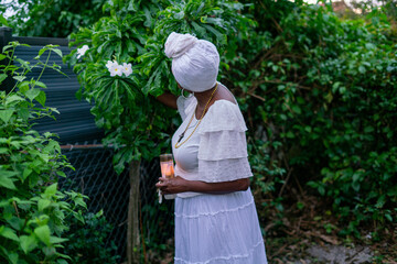 Woman praying in garden with candle