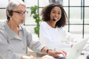 Fototapeta premium Young friendly operator woman agent with headsets working in a call centre.