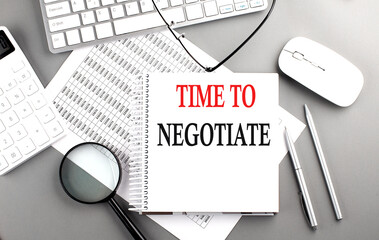 TIME TO NEGOTIATE text on notepad on chart with keyboard and calculator on grey background