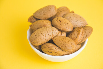almonds in a plate on a yellow