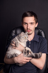 Obraz premium emotions of a young man who holds his beloved cat in his arms.