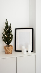 Mockup poster frame, Christmas tree with lights garland and candles in modern minimalist living room interior