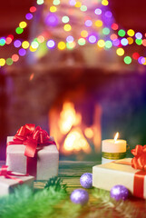 Christmas gifts with Christmas tree toys and a candle by the blazing fireplace.