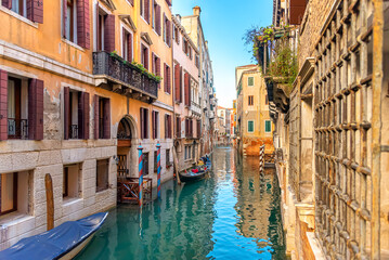 View of Venice narrow canal, old houses and gondola