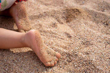 close shot of children feet on a sandy beach