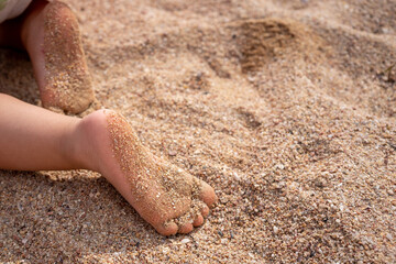 close shot of children feet on a sandy beach
