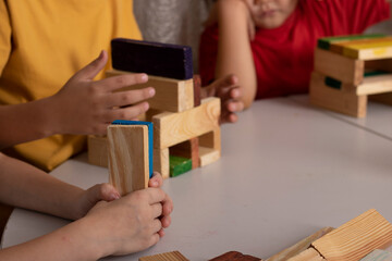 Kids playing with colorful wooden toy blocks