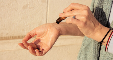 Essential oils roller bottle in the hand of a woman. Using a roller