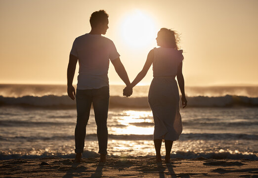 Beach silhouette, couple holiday and sunset with love, hold hands and love together, support and holiday. Man, woman and vacation at ocean, travel and romance for anniversary, honeymoon and sea trip