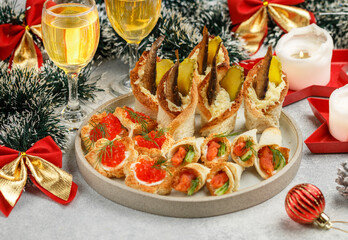 festive snack of fish and seafood. Caviar canapes, sandwiches with red salted and smoked fish, cucumber, dill, sprats, sardines. New Year, Christmas 